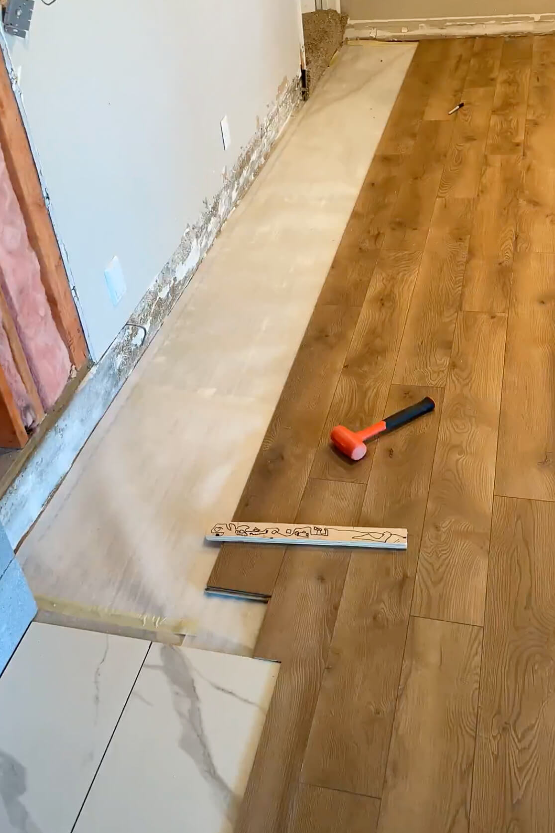 Cutting laminate flooring to fit against an edge.